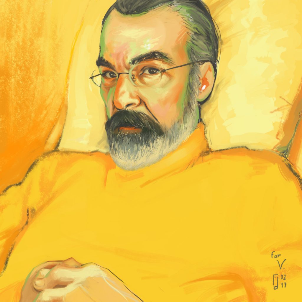 Portrait of a greying bearded man leaning against a cushion. He wears glasses and a yellow sweater.